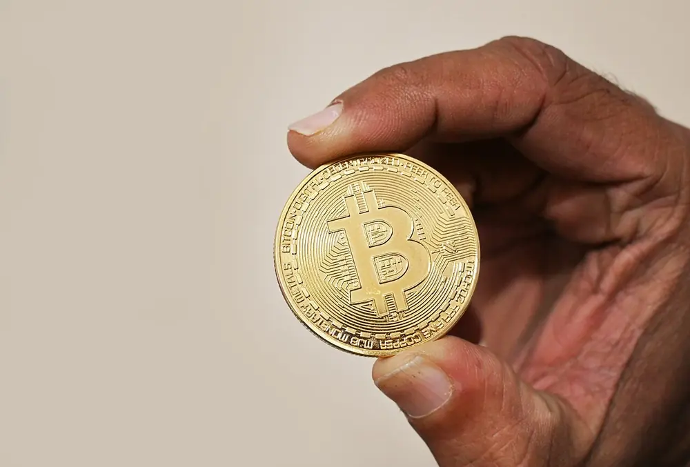 sosteniendo una moneda de bitcoin